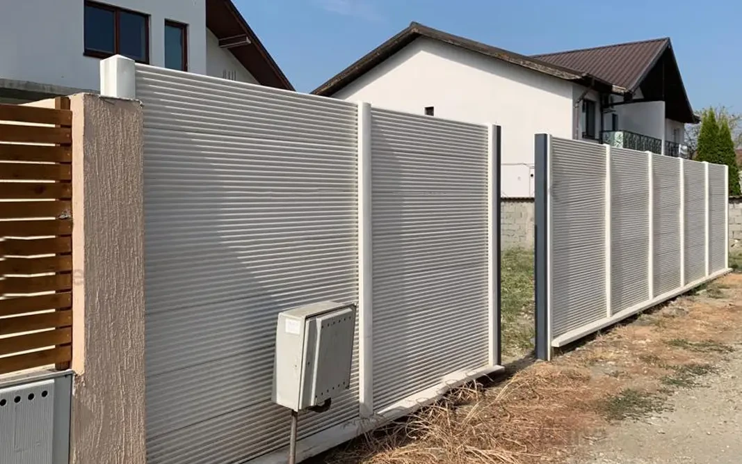 Betonový plot s jemným vodorovným reliéfem před domem
